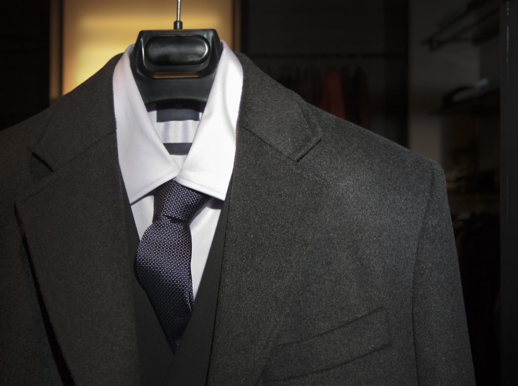 Suit, vest, shirt and necktie on a hanger.